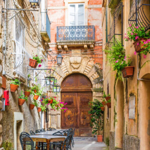 Cafe tables and chairs outside in old cozy street in the Positano town, Campania, Italy